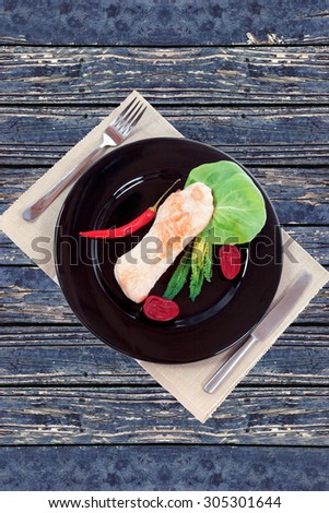 fresh roast turkey meat fillet steak served with vegetables on plate over blue wooden table