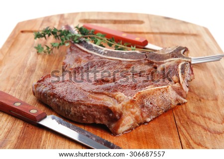 meat food : roast rib on wooden plate with thyme isolated over white background . shallow dof