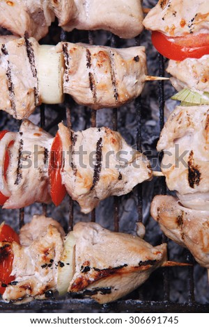 fresh turkey pink brisket shish kebab on wooden skewers with tomatoes over barbecue brazier full burned charcoal