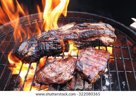 fresh red grilled beef meat fillet asado on deep round bbq grill over fire