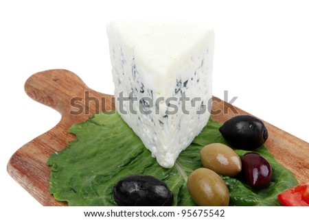 blue mold cheese on wooden platter with olives and tomato isolated over white background