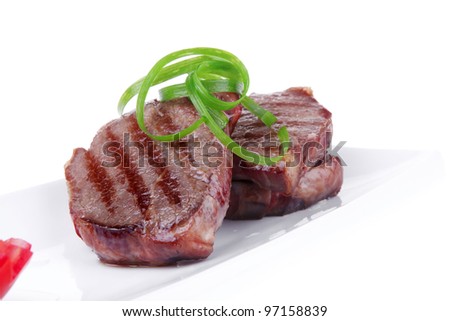 roast meat beef fillet strips on white plate isolated over white background