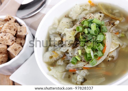 diet food : hot vegetable soup with bread  crackers in white bowl on  stand over wood table