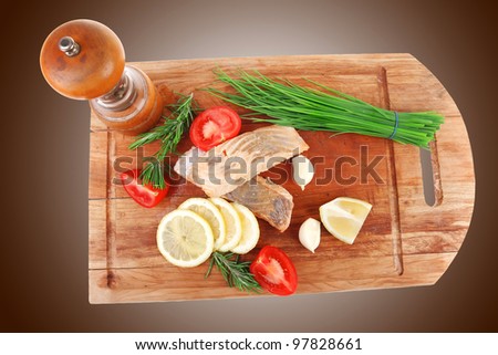 sea food : roasted pink salmon fillet with chinese onion, cherry tomatoes pieces, pepper grinder, rosemary twigs and lemon on wooden board isolated over white background