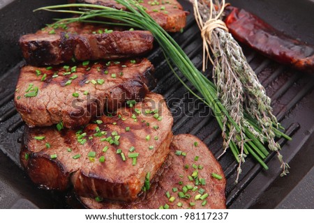 fresh ripe roasted beef meat on barbecue pan with thyme and pepper isolated on white background