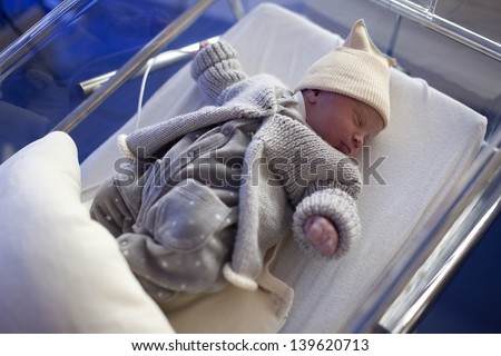 Cute newborn in nursery at the hospital