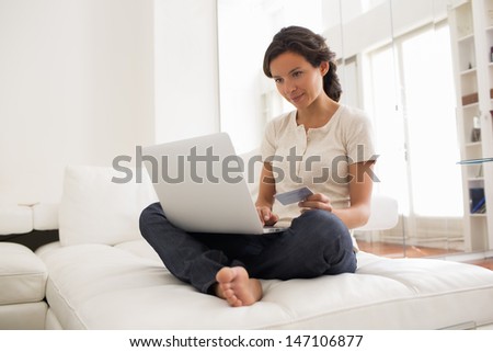Pretty woman holding credit card and using laptop - indoor