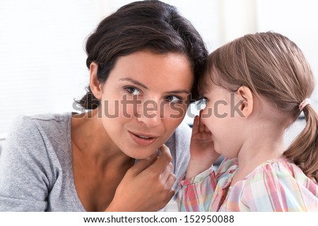 A little girl telling her mother a secret, indoor