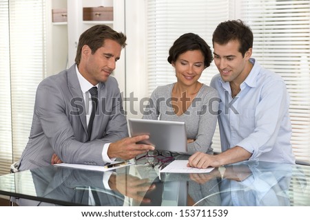 Financial consultant presenting a new project investment to a smiling young couple