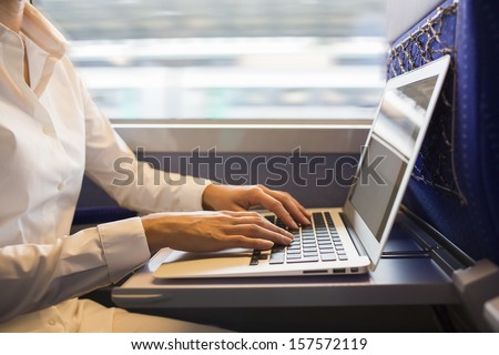 Close-Up Woman Hands Typing On A Laptop Keyboard In The Train