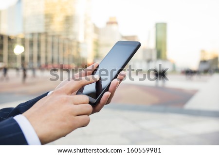 Businesswoman Sending Messages With Her Smart Phone In Front Of Building