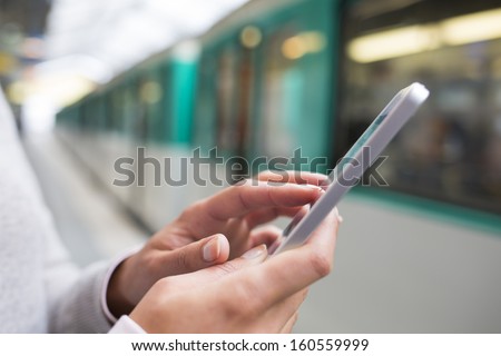 Woman using her cell phone on subway platform
