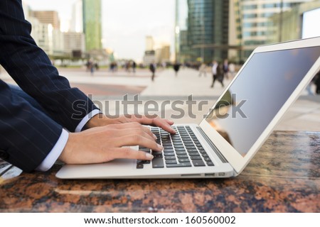 Businesswoman Using Her Laptop In Working Environment, Building Background