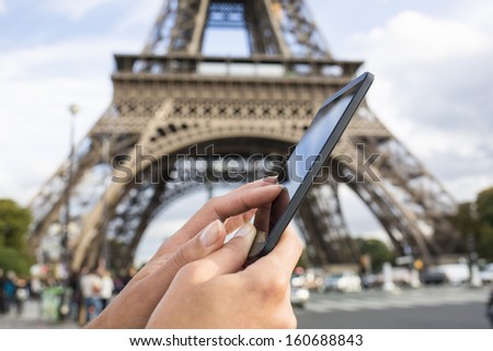Woman In Paris Using Her Smart Phone In Front Of Eiffel Tower