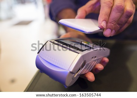 Man Paying With Nfc Technology On Mobile Phone, In Pharmacy