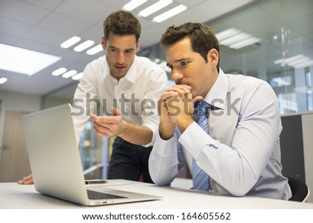 Two Handsome Businessmen Working Together On A Project In The Office