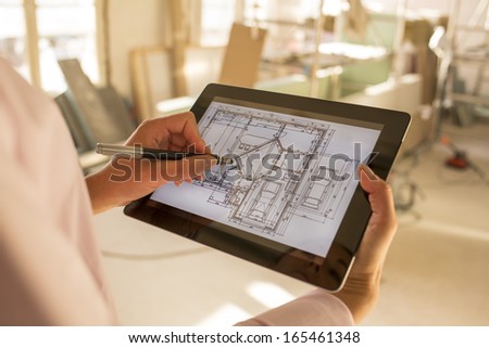 Architect woman working with stylus on electronic tablet
