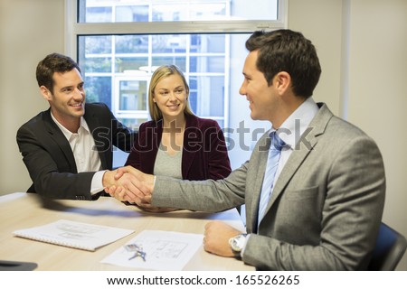 Couple meeting with financial adviser, handshake