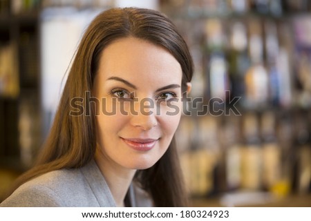 Portrait of pretty young woman in restaurant, looking camera