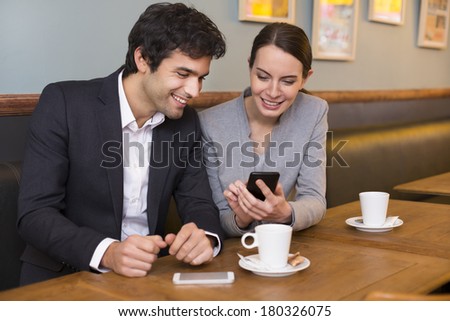 Young couple using a smartphone in restaurant