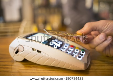Man paying with NFC technology on credit card, restaurant, shop
