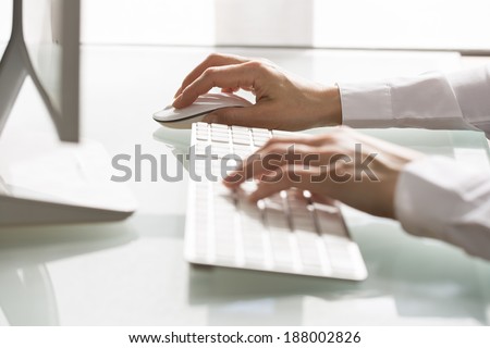 Close-up of hands woman using a mouse and keyboard computer