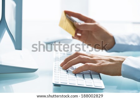 Woman shopping using computer and credit card .indoor.close-up