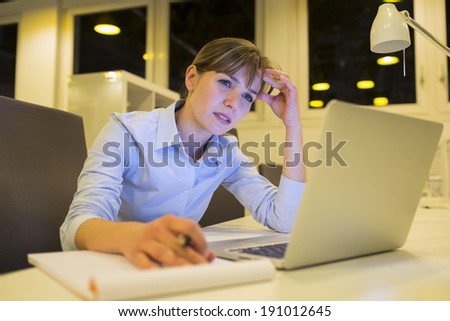 Stressed business woman working late in office