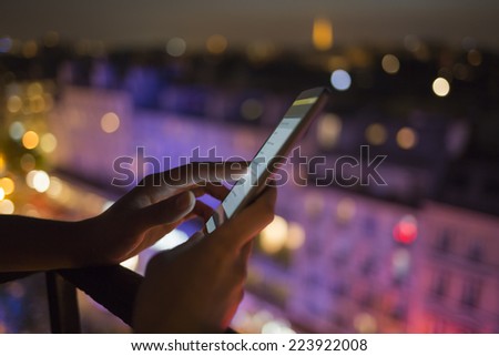 Woman using her smart phone , city skyline night light  background