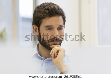 Portrait of handsome hipster style bearded man in office