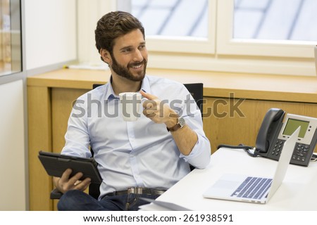 Handsome hipster bearded businessman working in office on computer