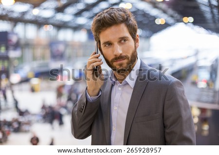 Handsome man on the mobile phone in hall station