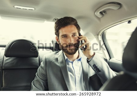 Hipster man in car on mobile phone. Filter vintage