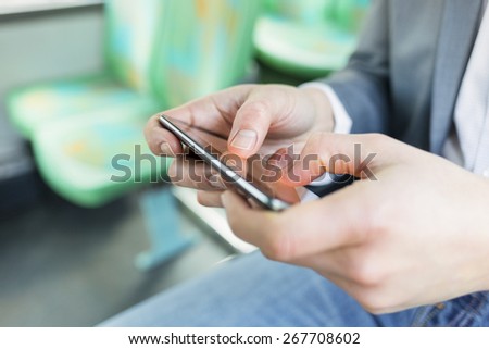 On bus man texting sms, using cell phone apps. gaming. Close-up hands