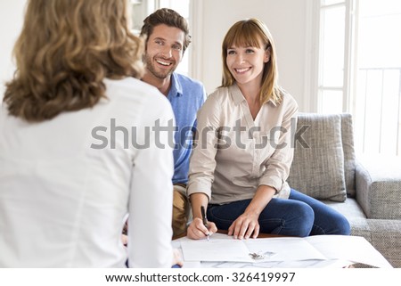 Young couple owners meeting real estate agent for house investment. Signing a contract