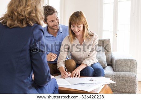 Young owners couple signing a contract for house investment.