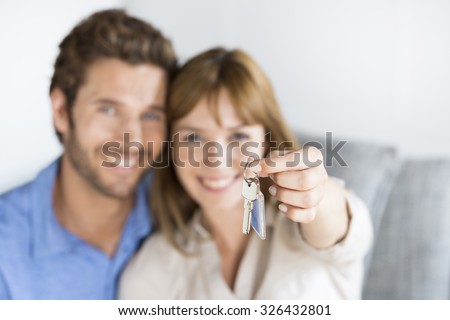 Cheerful thirty year old  couple showing a keys of their new apartment.