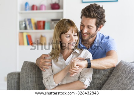 Man shows his new smart watch to his wife.