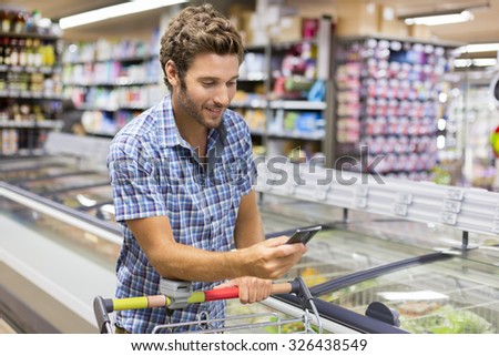 Cheerful man using app mobile phone in store