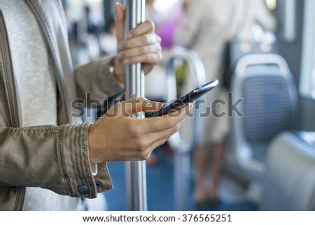 Woman using her cell phone on bus. Sms, message, app