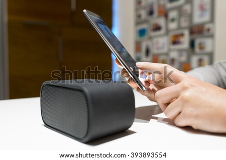 Woman connect their smart-phone to speakers. Nfc, bluetooth