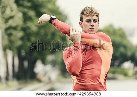 Young athletic man stretching outside