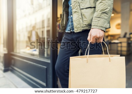 Man shopping in clothing store carry a paper bag