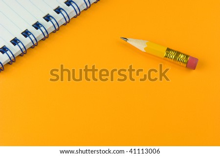 Short pen and memo pad on yellow ground