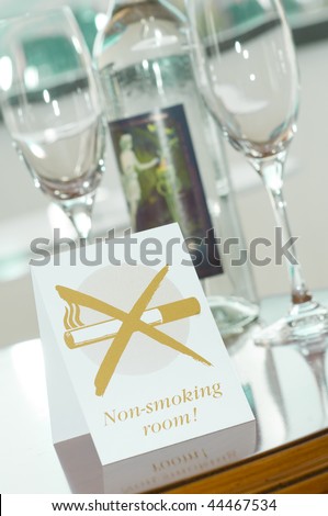 Non-smoking-room label on a desk with glasses and a bottle of mineral water