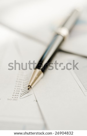 Pen on  financial papers. Lots of copy space.