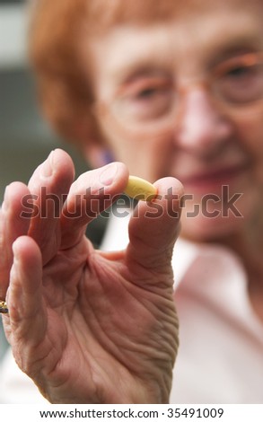 senior woman holding pills