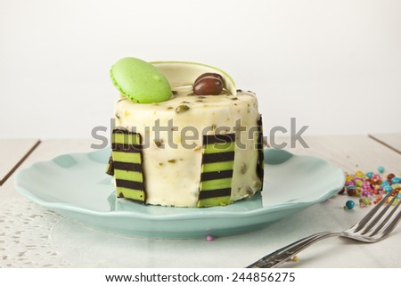 Pistachio cheesecake, mousse cake with nuts decoration on a white plate