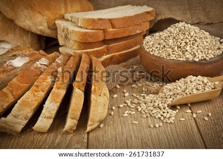 Wheat Bread, wheat seeds and bread slices with wooden background