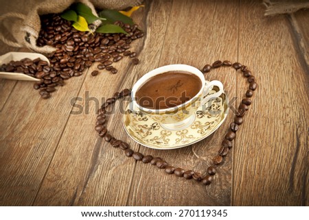 Traditional Turkish Coffee cup and coffee beans concept with love shape on wooden background